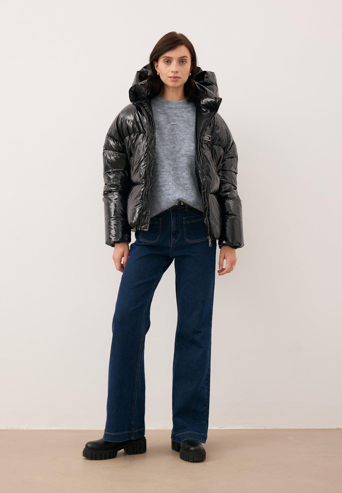 Model wearing the black SANYA puffer jacket unzipped, paired with the FAROA sweater and DELPHI jeans.