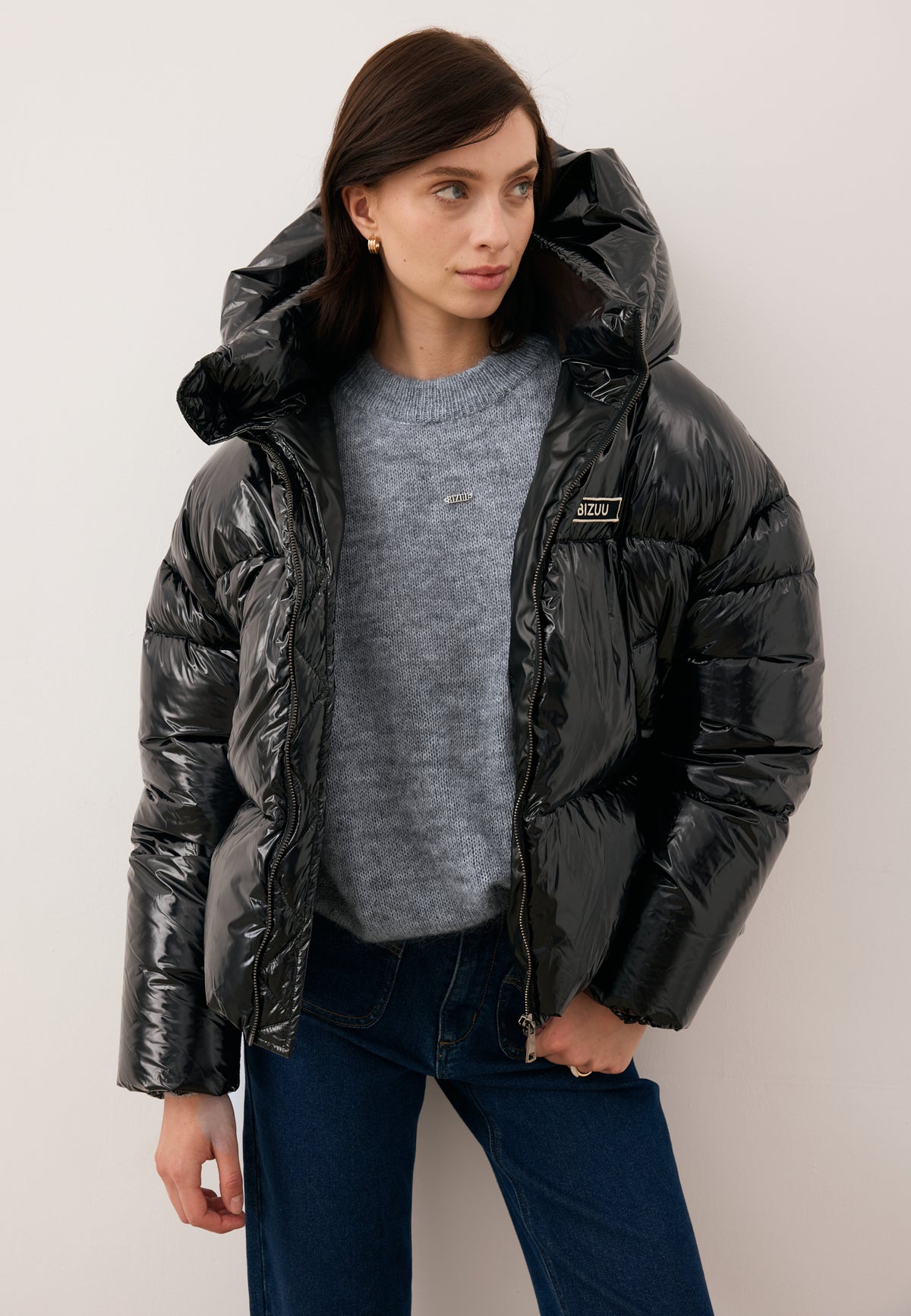 Model with one hand in the pocket of DELPHI jeans wearing the black SANYA puffer jacket.