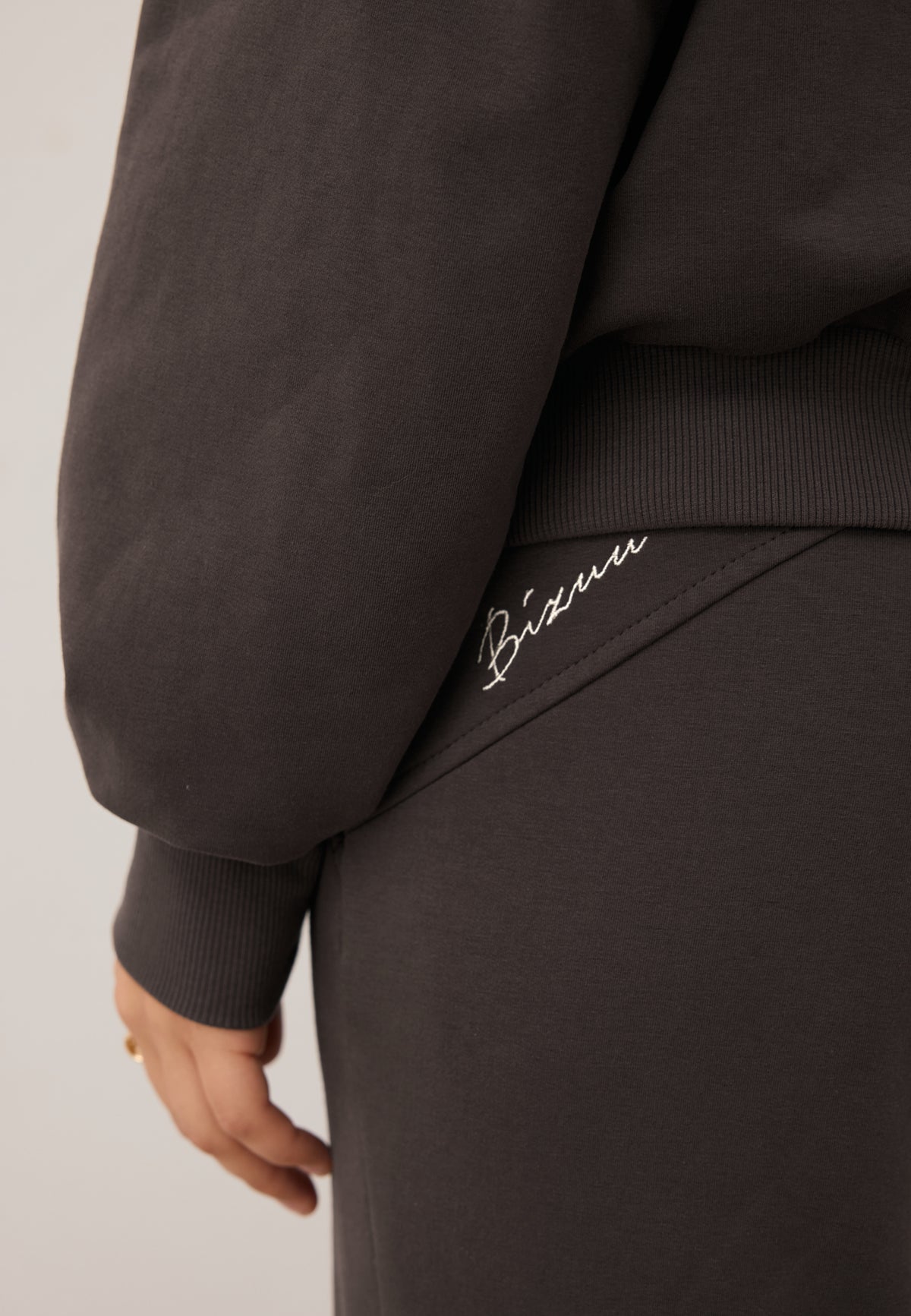 Detailed close-up of the embroidered BIZUU logo on the ZEIA trousers.