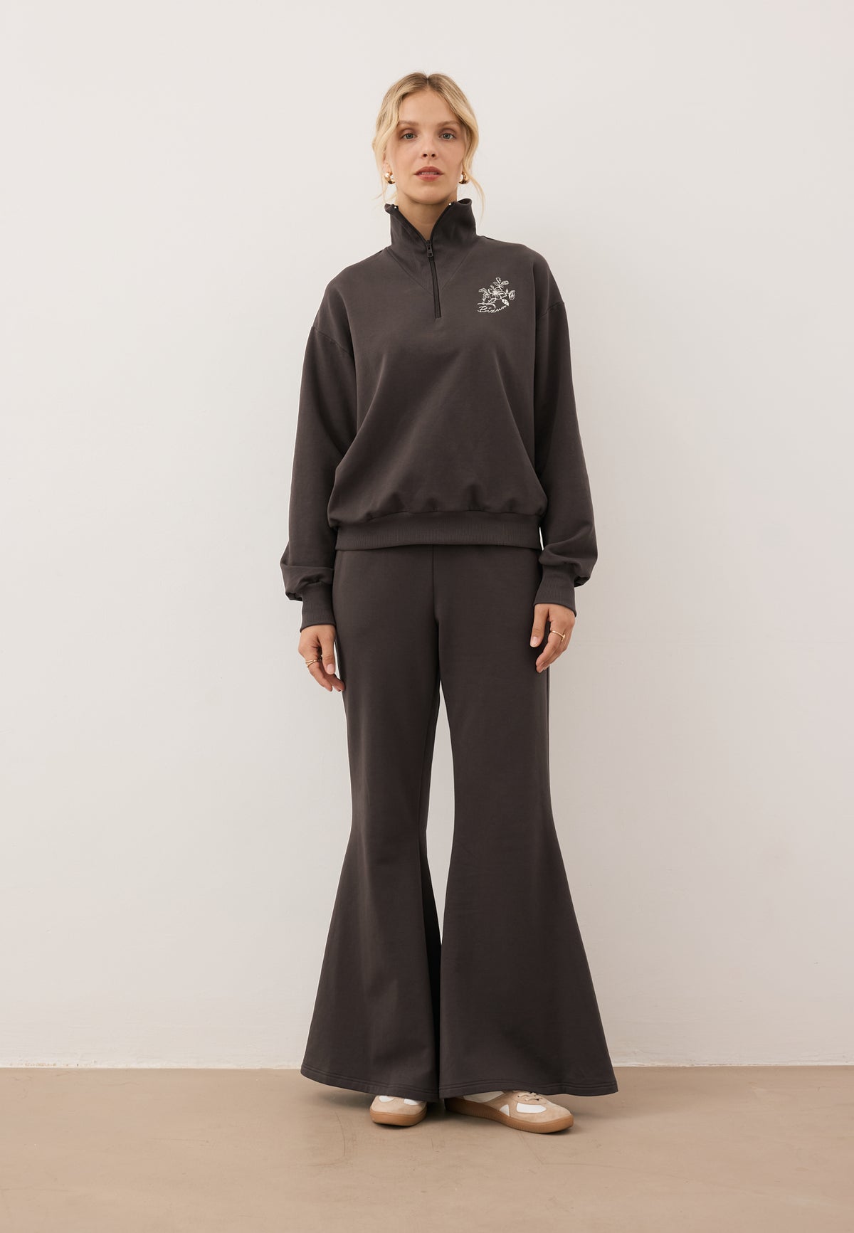 Model wearing the chocolate-colored tracksuit set with the TANSY half-zip sweatshirt and ZEIA wide-leg trousers.