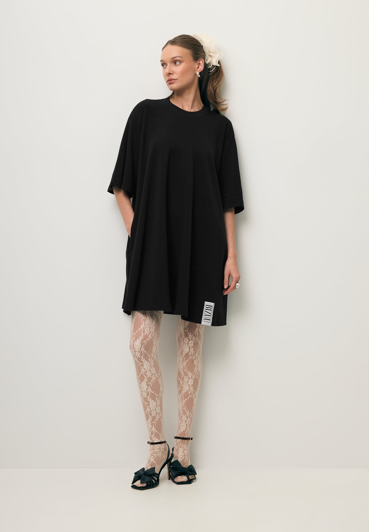 A model wearing the TRESS knit dress with white lace tights.