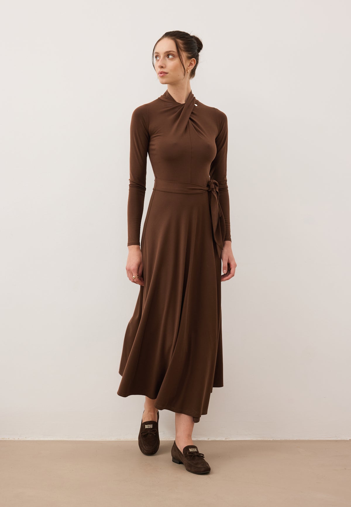 Model taking a step in the midi ROTTA dress with an asymmetrical hem.