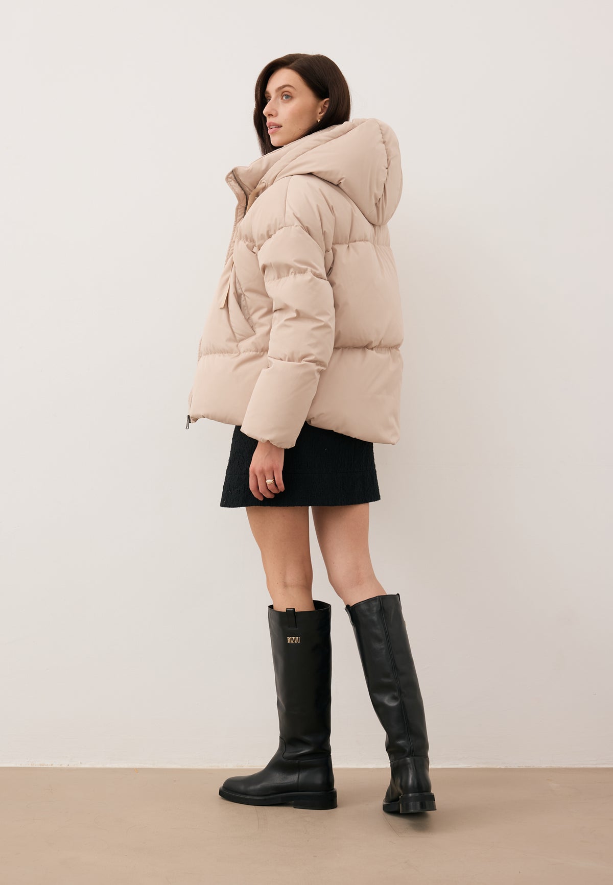 Model wearing the black YOKO jacket with natural filling and the FLACE skirt.