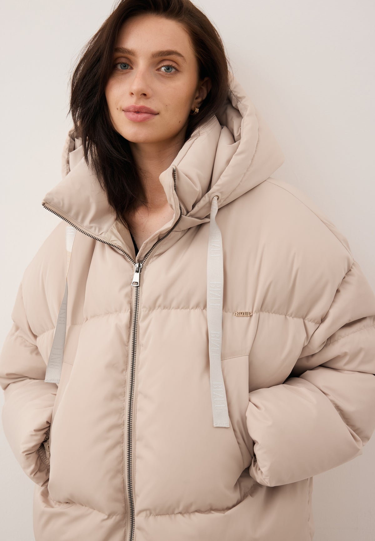 Model standing with her back turned in the YOKO winter jacket with natural filling.