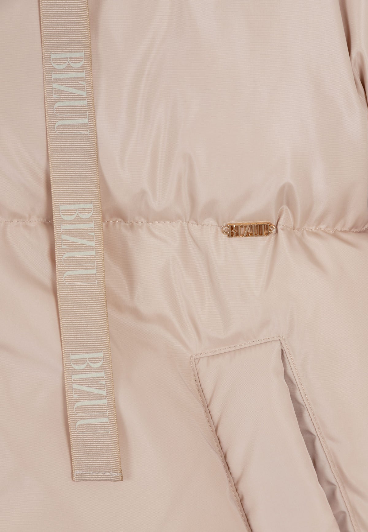 Close-up of the gold logo and branded drawstrings on the front of the black YOKO jacket.