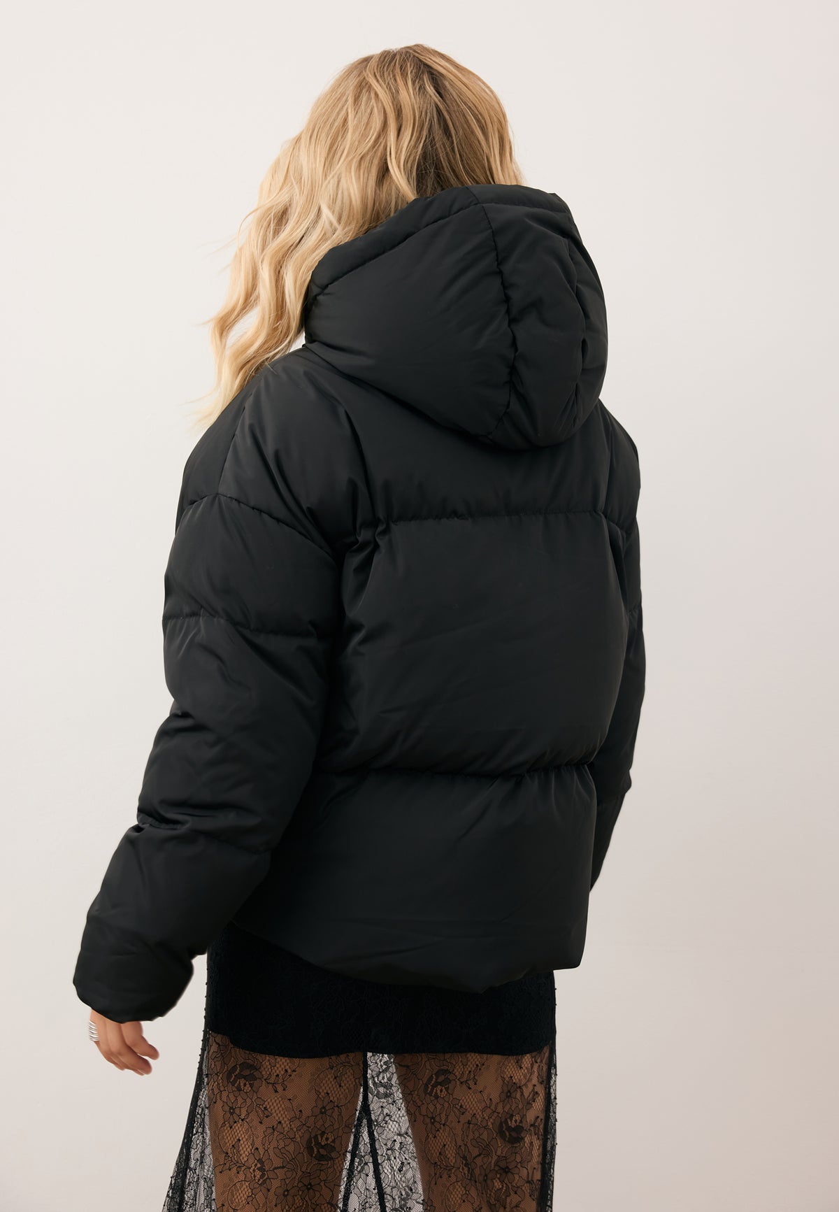 Model standing with her back turned in the YOKO winter jacket with natural filling.