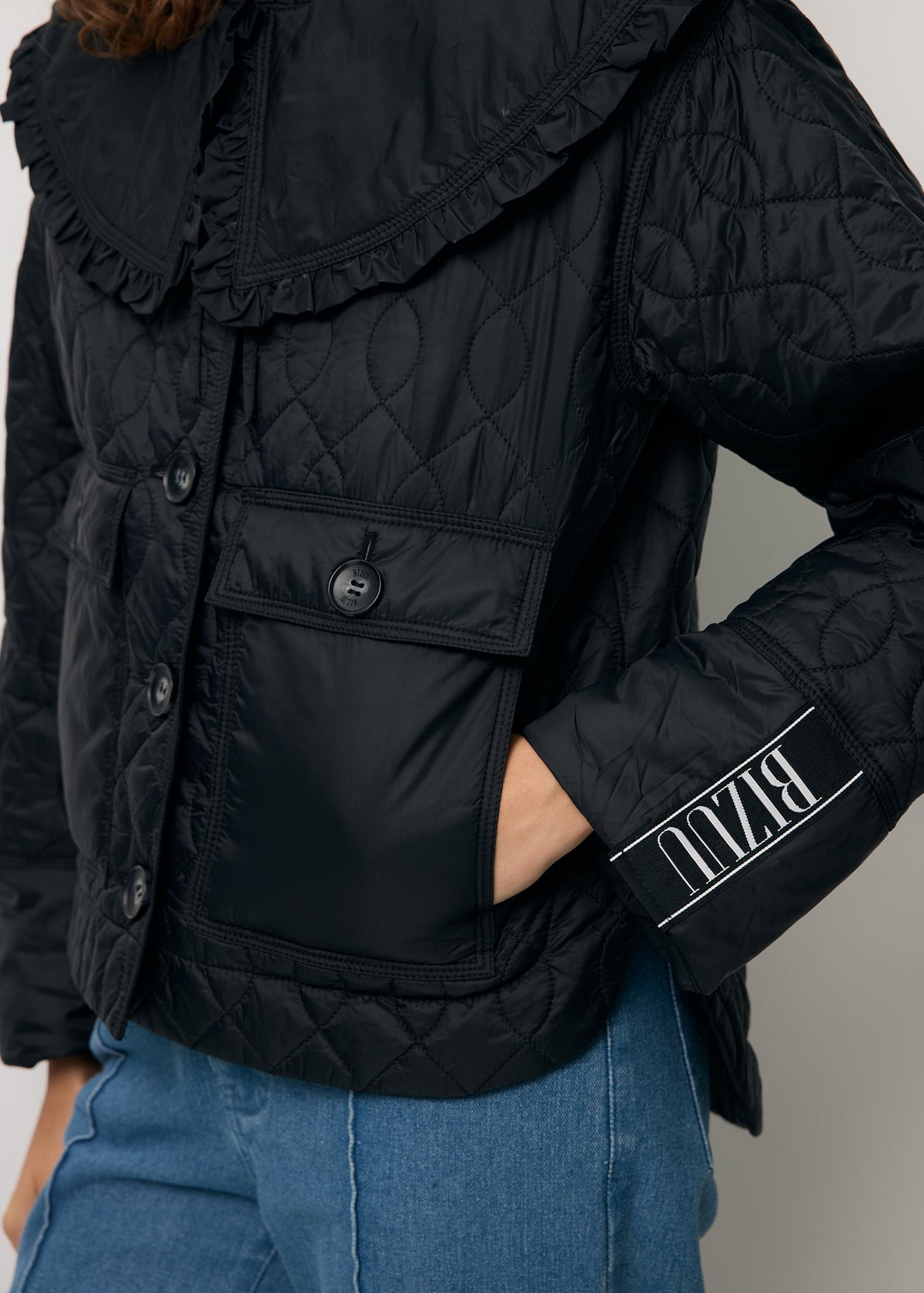 Close-up of the sleeve with a logo tape detail on the quilted ZANNI jacket.